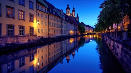 Obraz premium A peaceful night scene of Munich with its historic buildings softly illuminated by streetlights and the Isar River reflecting the calm cityscape above the streets are quiet and almost empty capturing