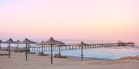 Photo of an empty beach at a purple sunset.