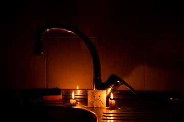 Candles near the kitchen faucet on the sink and a sad emotion on paper drawn in an apartment in...