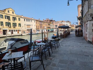 An outdoor restaurant seating on the canal, Venice, Italy on 18-06-2023