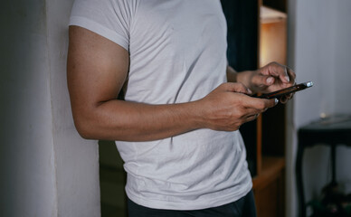 Close-up hands of asian male freelancer holding and typing on mobile phone.