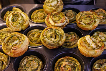 Crispy courgette puff pastry snails on a baking tray