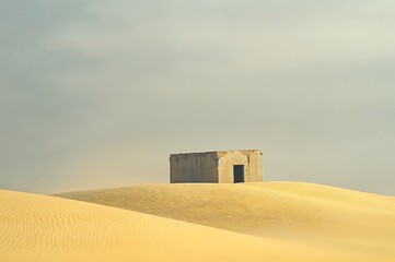 Solitary concrete building amidst the serene and expansive desert landscape.