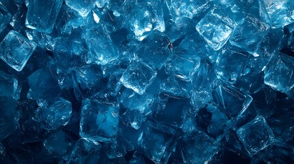 Top view of blue ice cubes in a pile on a dark background, close-up. Textured background for product presentation with copy space. Background for design