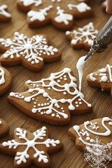 An overhead view of a wooden table covered with decorated gingerbread cookies for Christmas