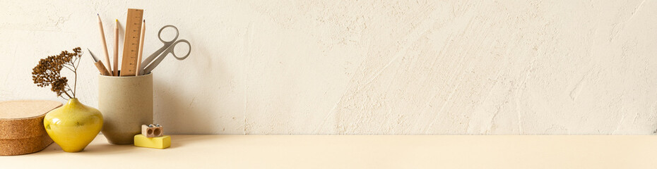 Desk at home office with supplies and wall copy space. Stylish minimalist workspace.. Table on light beige stucco background.	
