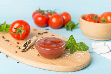 Delicious ketchup with spices and tomatoes on wooden table