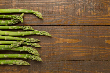 Fresh asparagus on wooden background, top view