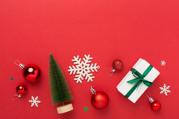 Small christmas tree with decor on color background, top view