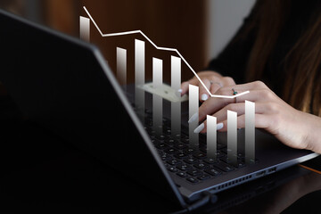 Analyzing Financial Data: Woman Using Laptop with Graph Overlay