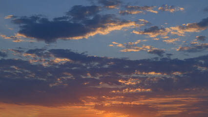 Summer evening sky in the picturesque clouds, lit by the rays of the setting sun.