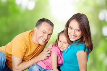 Cheerful young family sitting on the park.