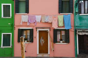 Wäsche hängt an den bunten Häusern auf der Insel Burano, Venedig