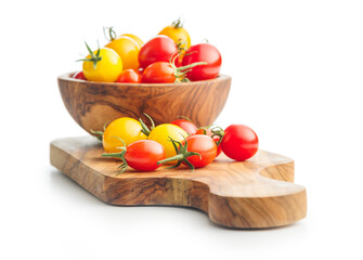 Different colorful cherry tomatoes on cutting board  isolated on white background.