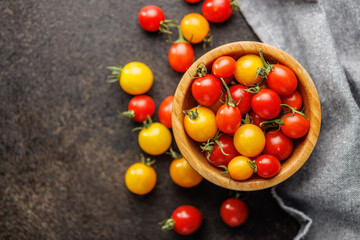 Different colorful cherry tomatoes in bowl. Top view.