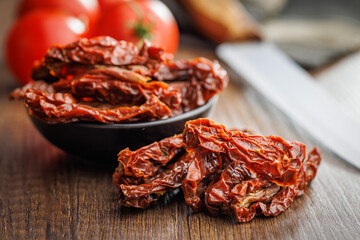 Sun dried red tomatoes on wooden table.