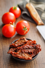Sun dried red tomatoes on wooden table.