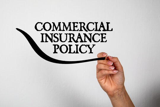 Commercial insurance policy. Text on a white background. Hand with pencil