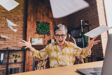 Photo of crazy mad furious senior lady sitting armchair working modern loft interior indoors...