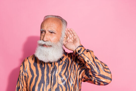 Portrait of funky aged man hand ear eavesdrop tiger print shirt isolated on pink color background