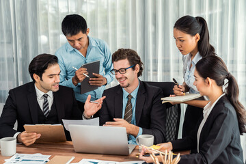 Diverse of business people from various ethnic group working in modern office environment. Productive and multi ethnic office workers engage in discussion for strategic business marketing. Meticulous