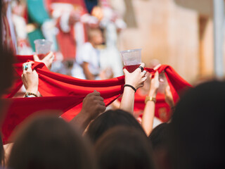 woman hands rise  traditional red bandana and a wine glass in spanish celebration san fermin....