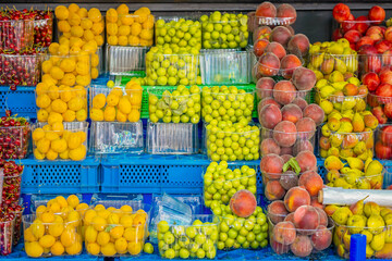 Colorful display of fresh fruits at local market showcasing various seasonal produce in baskets and containers