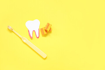 Paper tooth with brush and chewing gums on yellow background
