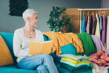 Photo of adorable woman dressed white cardigan reading planner cleaning tasks duties indoors house apartment room