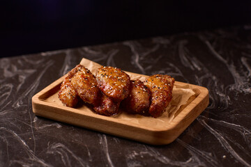 Succulent and Deliciously Glazed Asian Style Chicken Wings Served on a Wooden Platter
