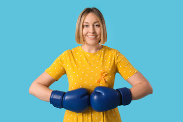 Happy mature woman in boxing gloves with ribbon on blue background. Multiple Sclerosis Awareness...