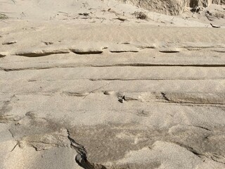 Uneven tracks in the sand with shadows
