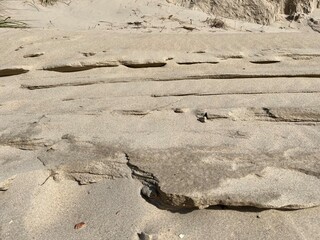 Uneven tracks in the sand with shadows