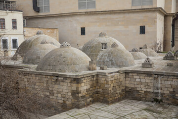 View of neighborhood from the roof. Ancient bath house in Baku, Azerbaijan . Amazing domes with convex glasses on scenic roof .