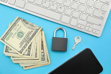 Computer keyboard with mobile phone, dollar banknotes, padlock and key on blue background. Cyber...