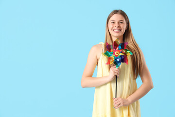 Young woman with toy windmill on blue background