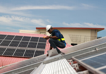 worker installing solar photovoltaic panels on a roof, Solar power plant engineers, and examining photovoltaic panels. Electrical and instrument technicians use laptop to maintenance electric solution