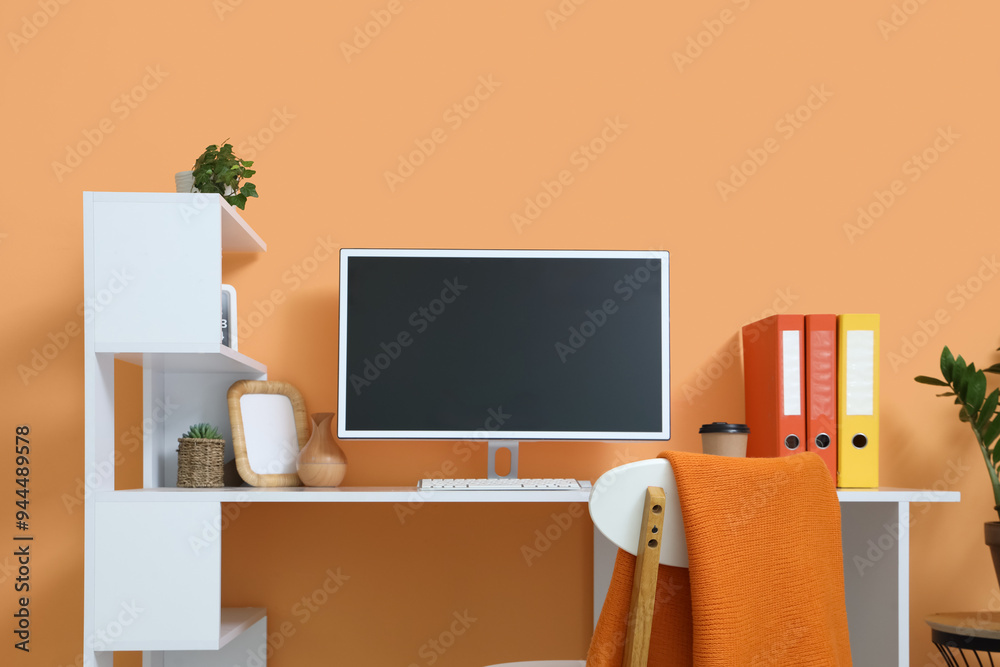 Wall mural comfortable workspace with modern computer near orange wall