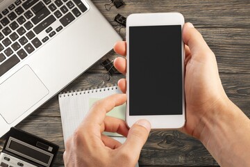 AHand typing on smartphone with blank screen