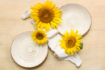 Beautiful table setting with sunflowers on beige wooden background