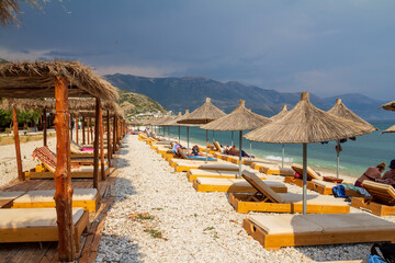 Borsh,Albania, July 10,2024: panorama of the beach with crystal water and white stone in a sunny but cloudy time ready to rain