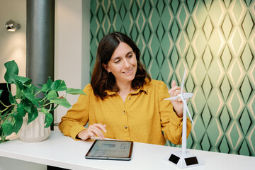 Businesswoman with windmill model in a modern office