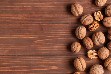 Many tasty walnuts on wooden background