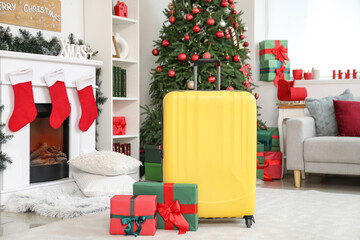 Suitcase with Christmas presents in living room