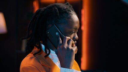 Student calling her professor to discuss about class materials, organizing study schedules and timelines based on online lessons. African american girl talking on smartphone call. Camera A.