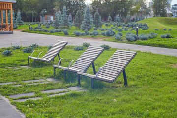 Wooden sun beds - benches in the city park.