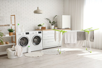 Interior of laundry room with dryer and washing machines