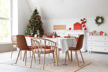 Dining table with Christmas setting and burning candles in room