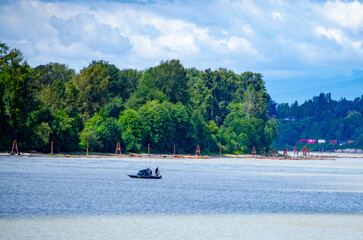Fishing Boat on the Fraser River with Lush Forested Shoreline in British Columbia