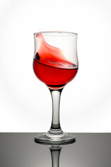 Red wine in glass in front of white background